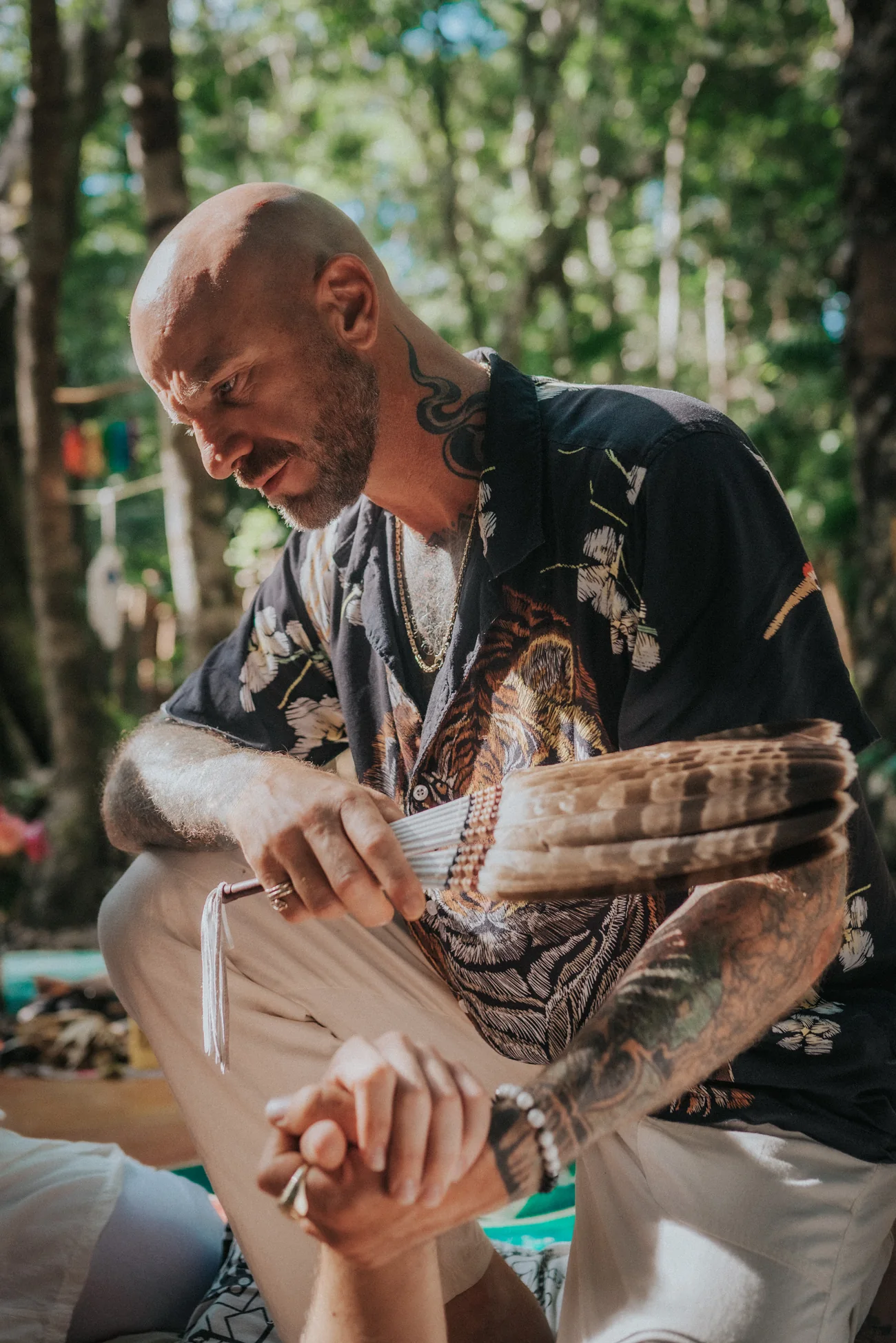 Blaine, founder of Tiger Soul, holding a feather fan during a jungle ceremony