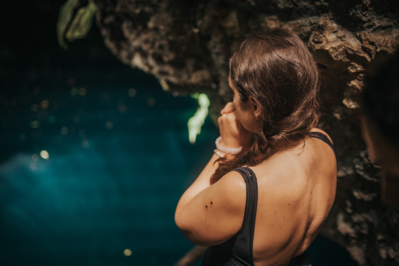 A woman floating in the still water of a cenote