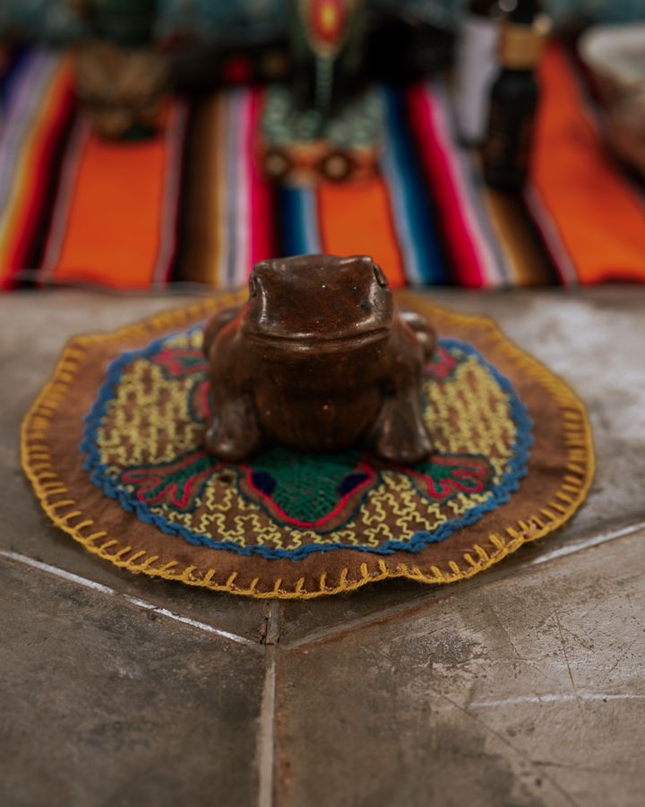 A carved bufo toad resting on a ceremonial cloth