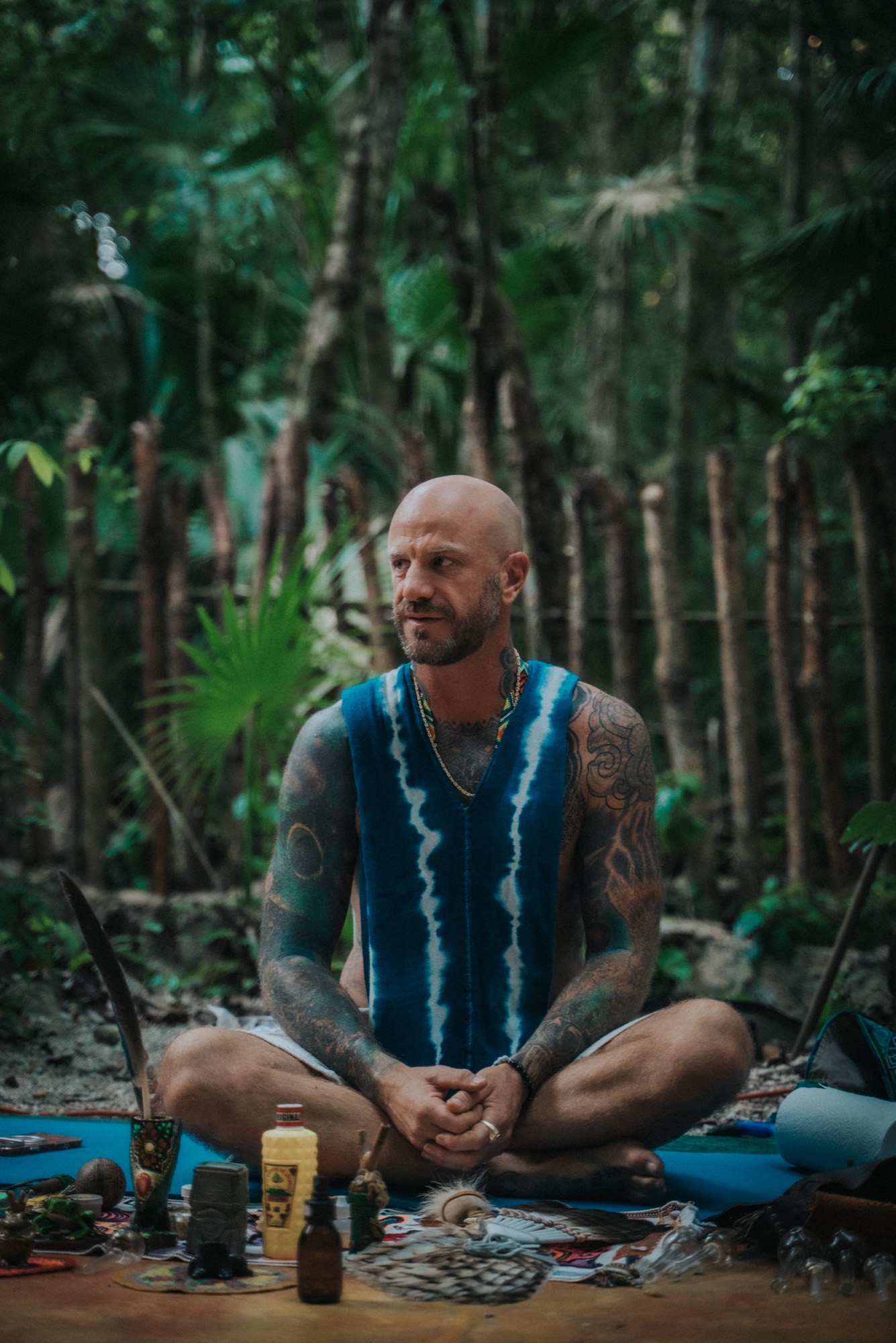 A facilitator seated behind a ceremonial altar in the jungle before a Bufo ceremony