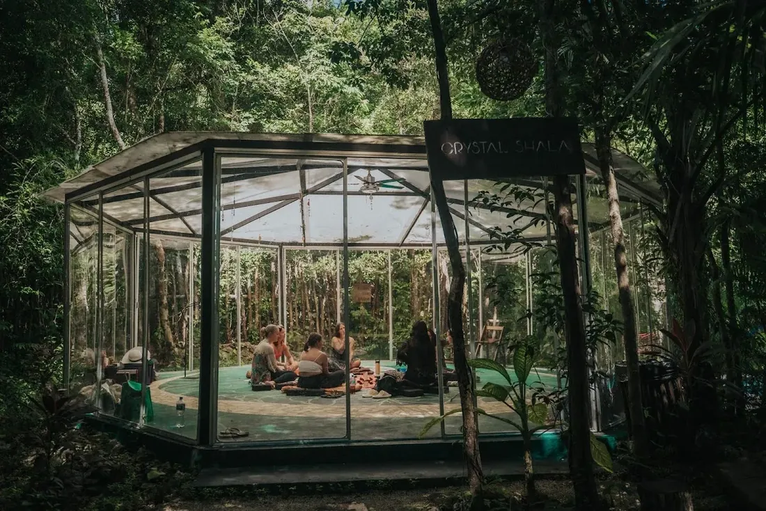 The glass Crystal Shala set in the jungle at Lunita, with a ceremony circle inside